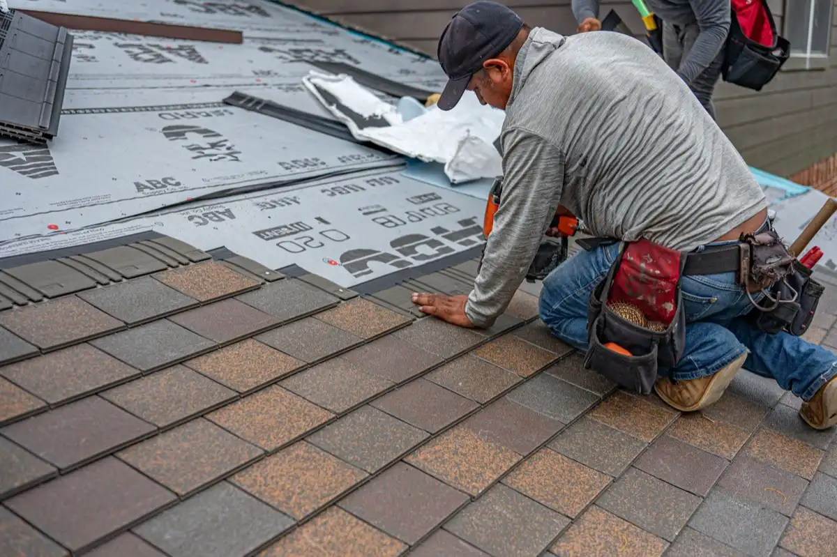 Roofing installer fastening shingles over new underlayment in Rancho Cucamonga, CA